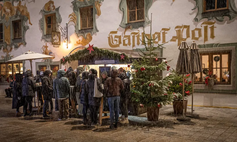 Crowd at a festive market by a decorated building