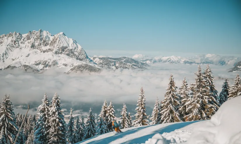 Snowy mountain landscape with a person skiing