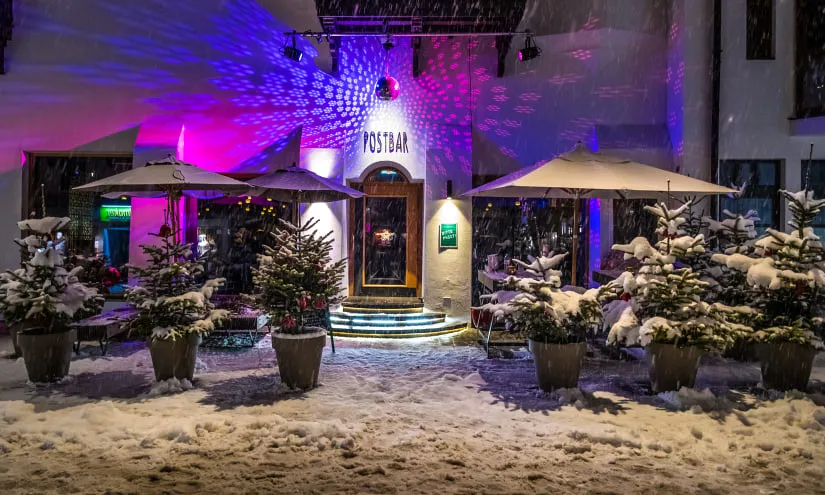 Illuminated Postbar entrance with snow and festive decor